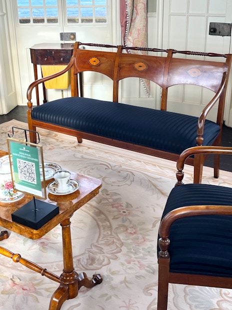 Elegant tea set on wooden table in historic room at Broadway Tower, Cotswolds tour from London.