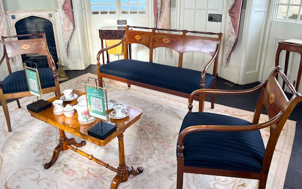 Elegant tea set on wooden table in historic room at Broadway Tower, Cotswolds tour from London.