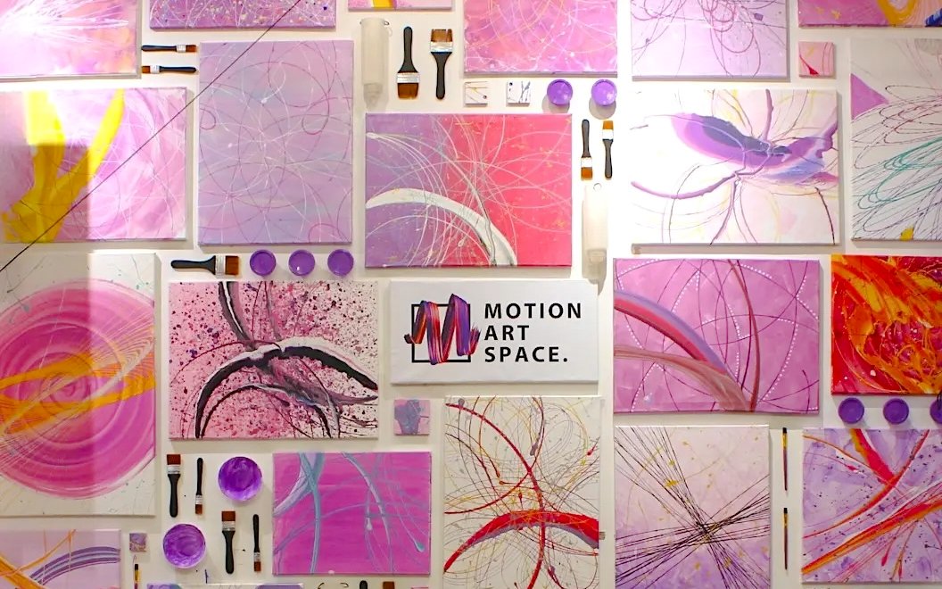 Abstract artwork display at Motion Art Space with vibrant pink and purple hues.