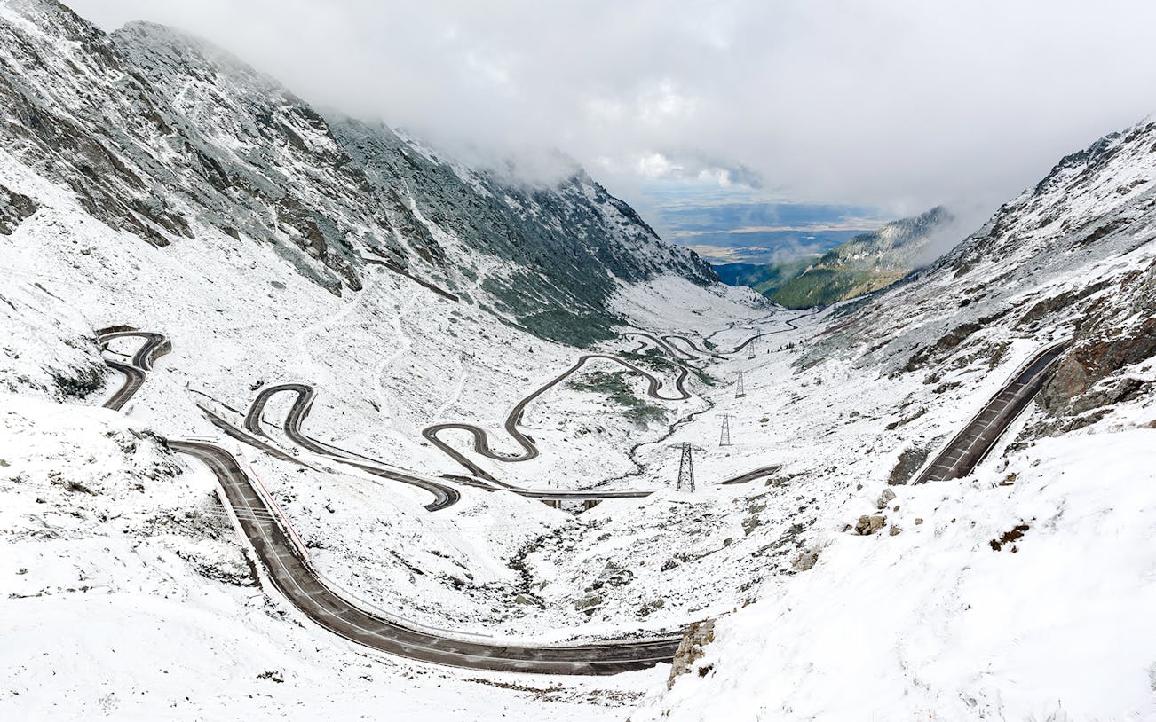 Winding Transfagarasan road covered in snow during winter, Romania.