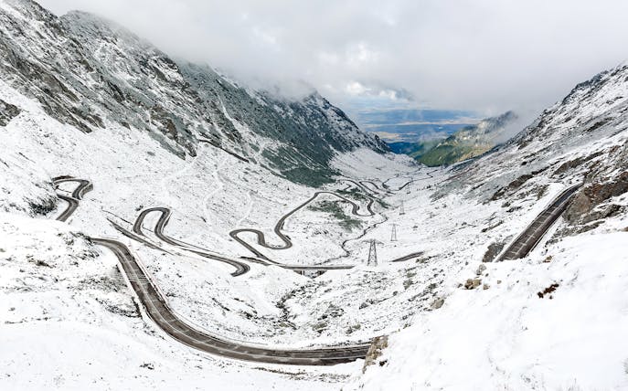 Winding Transfagarasan road covered in snow during winter, Romania.