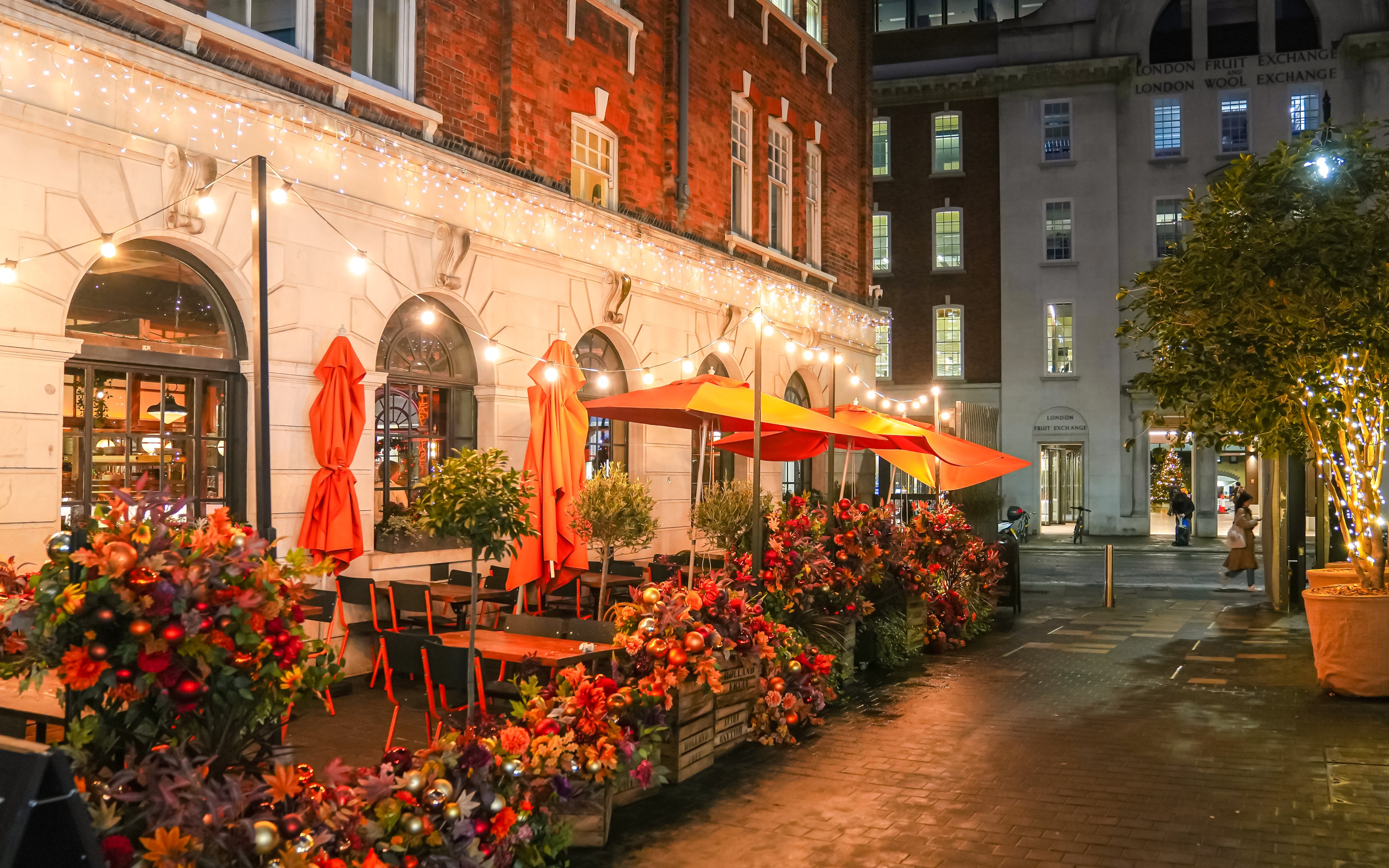 Outdoor seating with festive lights and decorations at Old Spitalfields Market, London during Christmas.