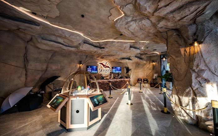 Interior of SkyFlyers attraction at Asiatique Bangkok with cave-like decor and ticket counter.