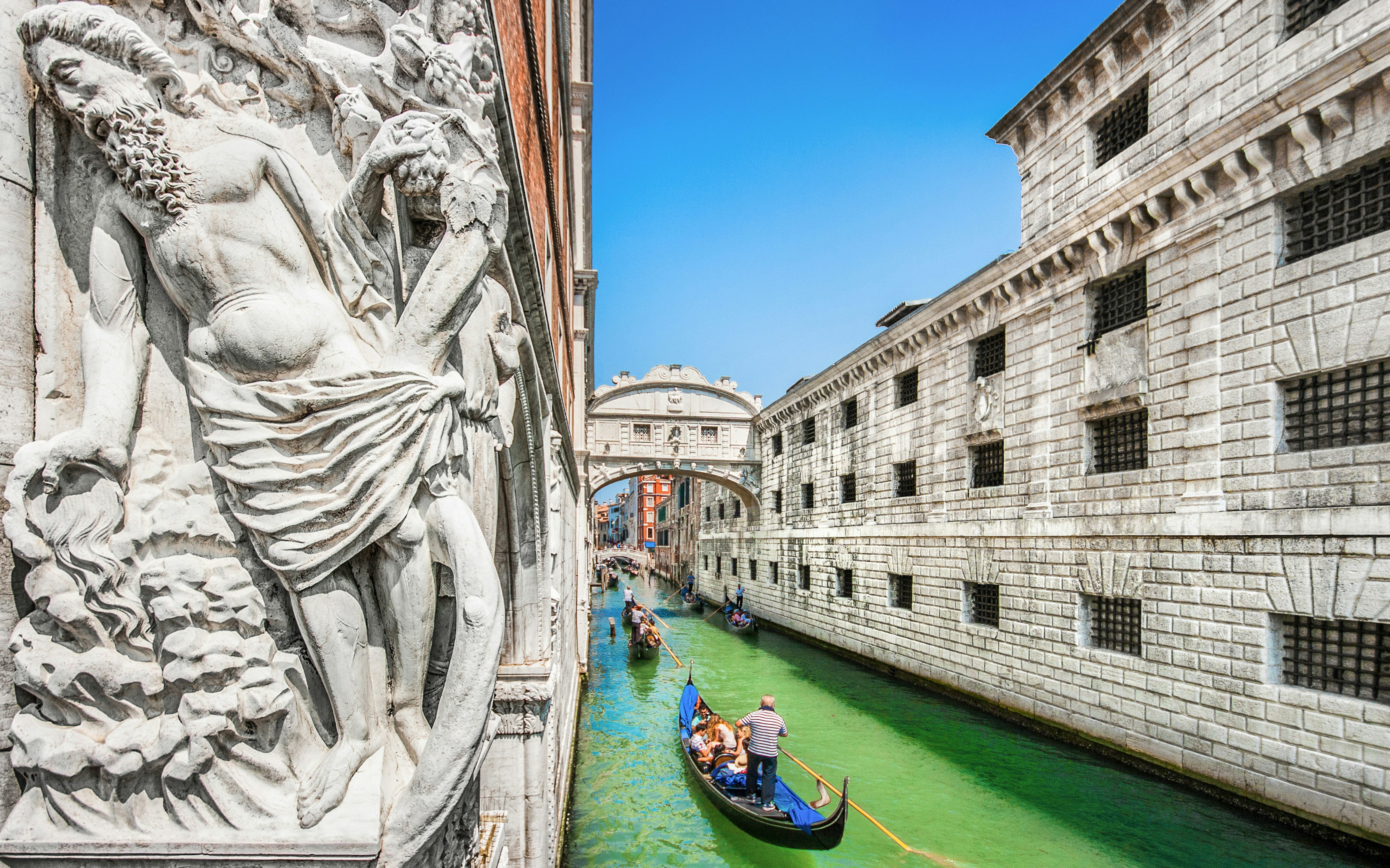 Gondola on canal near Bridge of Sighs and Doge's Palace in Venice, Italy.