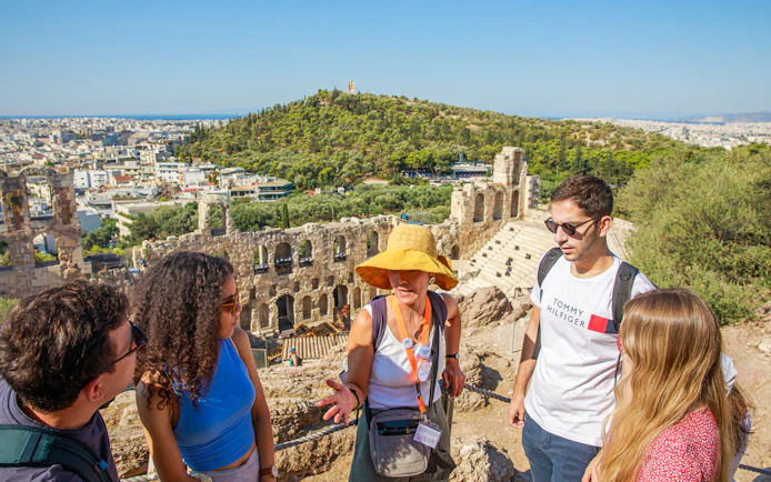 Tour group with guide at Acropolis overlooking Athens, Greece.