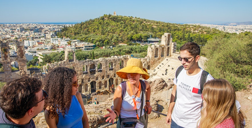 Tour group with guide at Acropolis overlooking Athens, Greece.