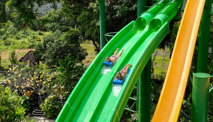 Two girls coming down the Twin Racers waterslide at Waterbom Bali water park