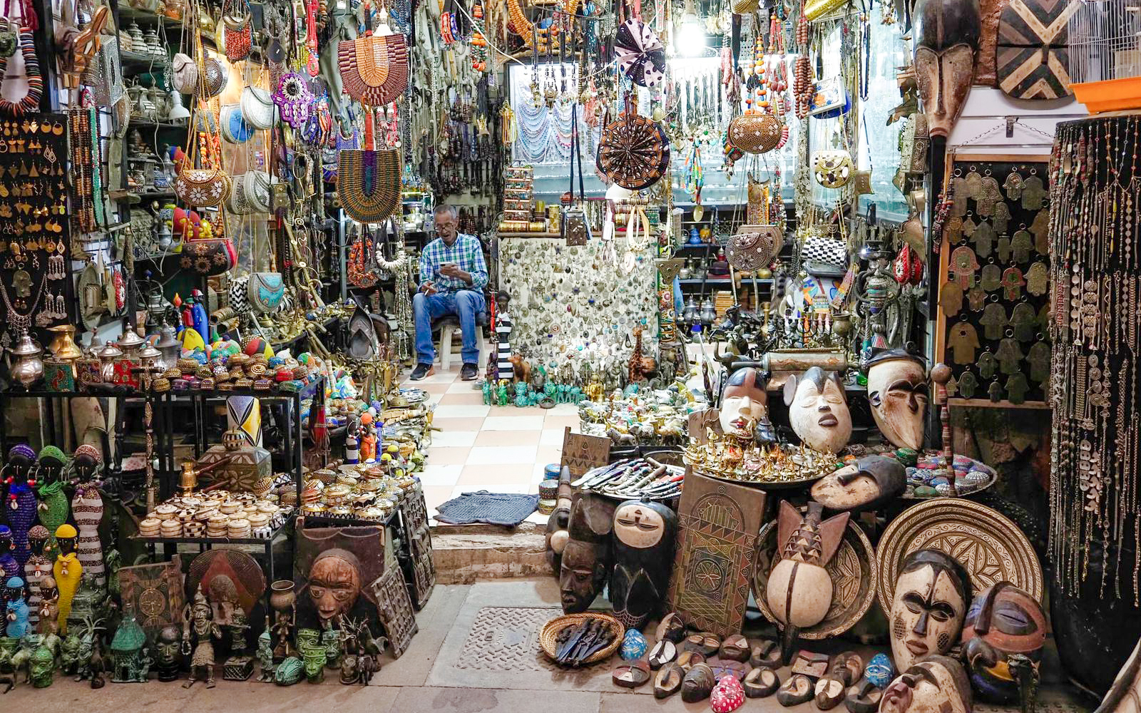 Market stall with traditional crafts and jewelry in Marrakech souk, Morocco.