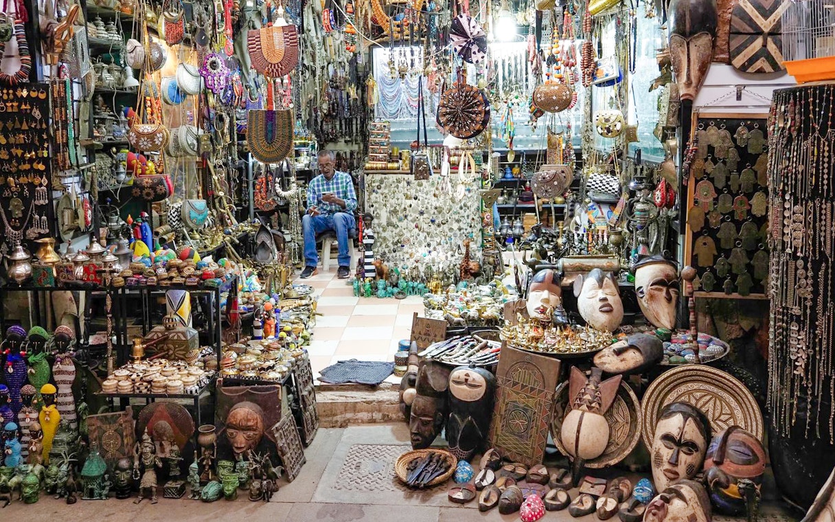 Market stall with traditional crafts and jewelry in Marrakech souk, Morocco.