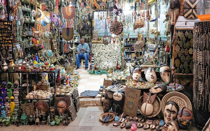 Market stall with traditional crafts and jewelry in Marrakech souk, Morocco.
