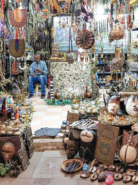 Market stall with traditional crafts and jewelry in Marrakech souk, Morocco.