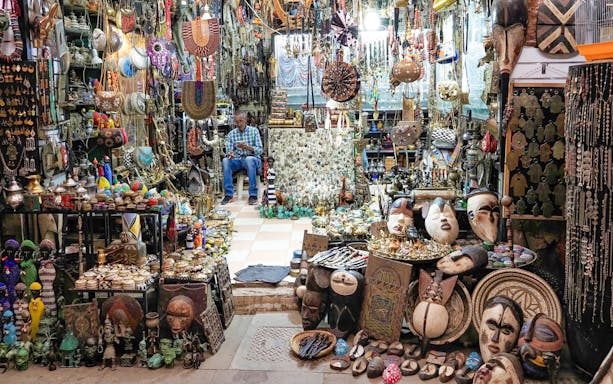 Market stall with traditional crafts and jewelry in Marrakech souk, Morocco.