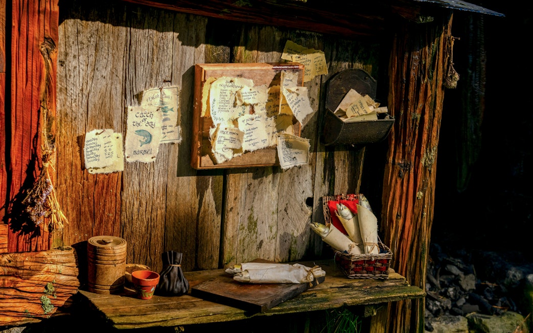 Desk setup with scrolls and notes in Hobbit house at Hobbiton movie set.