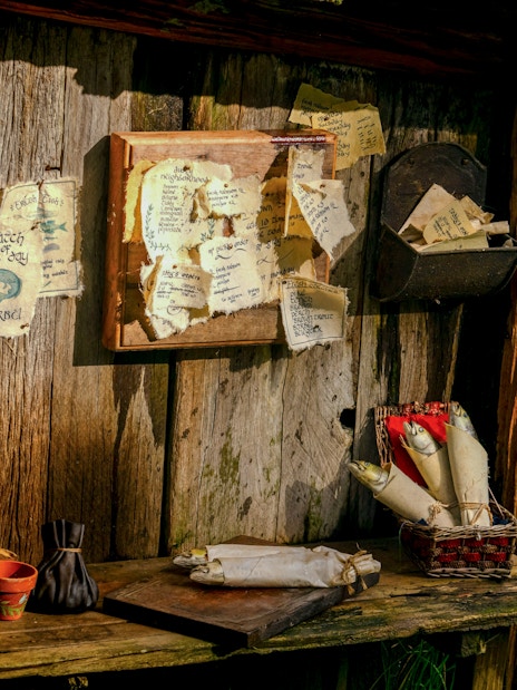 Desk setup with scrolls and notes in Hobbit house at Hobbiton movie set.