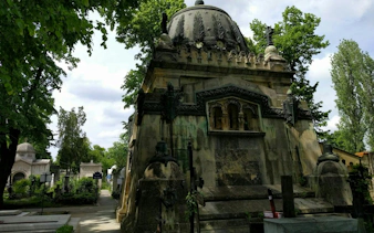 Bellu Cemetery mausoleum surrounded by trees, part of Bucharest self-guided exploration game.