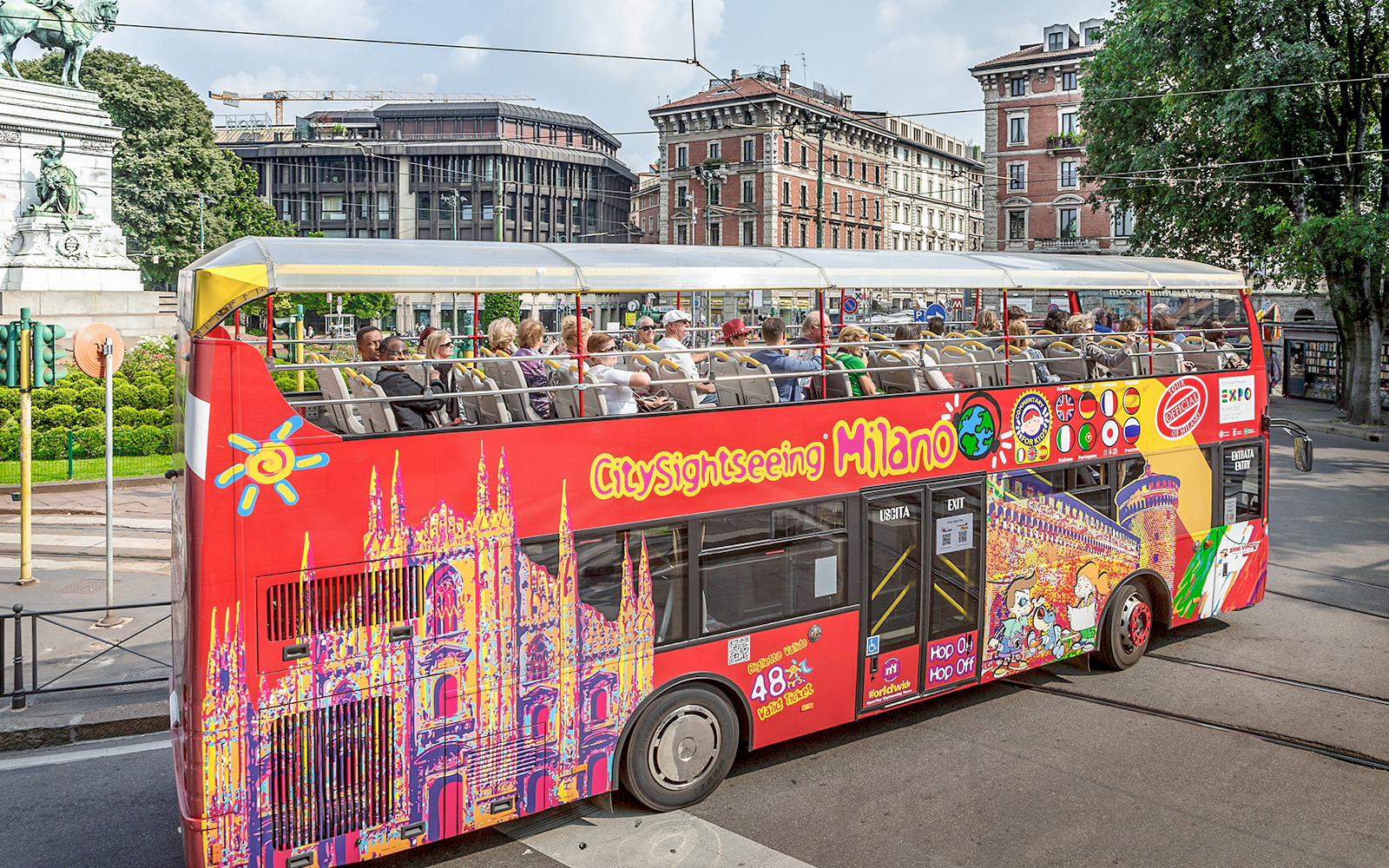 City Sightseeing Milan hop-on hop-off bus with tourists near historical buildings.
