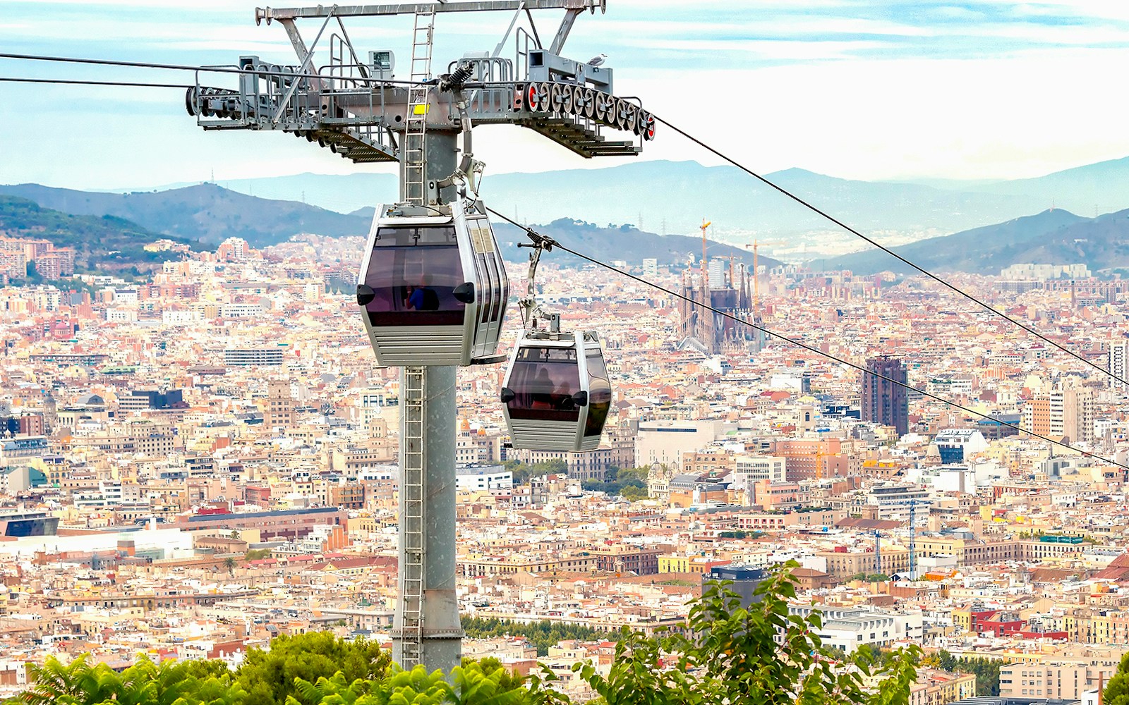 Cable car ascending Montjuic Hill with view of Sagrada Familia in back