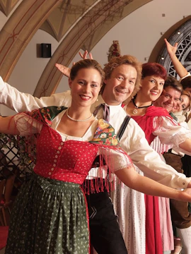 Traditional dancers in colorful attire performing at Vienna City Hall.