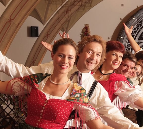 Traditional dancers in colorful attire performing at Vienna City Hall.