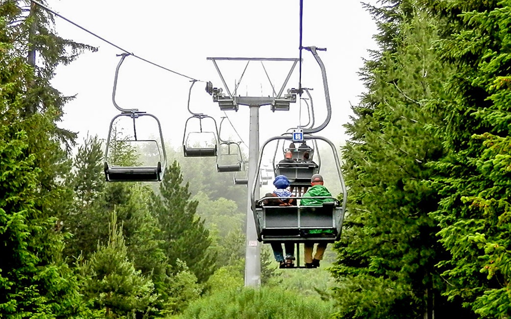 Chairlift ascending through forest during Rila Monastery and Seven Rila Lakes tour.