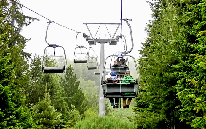 Chairlift ascending through forest during Rila Monastery and Seven Rila Lakes tour.