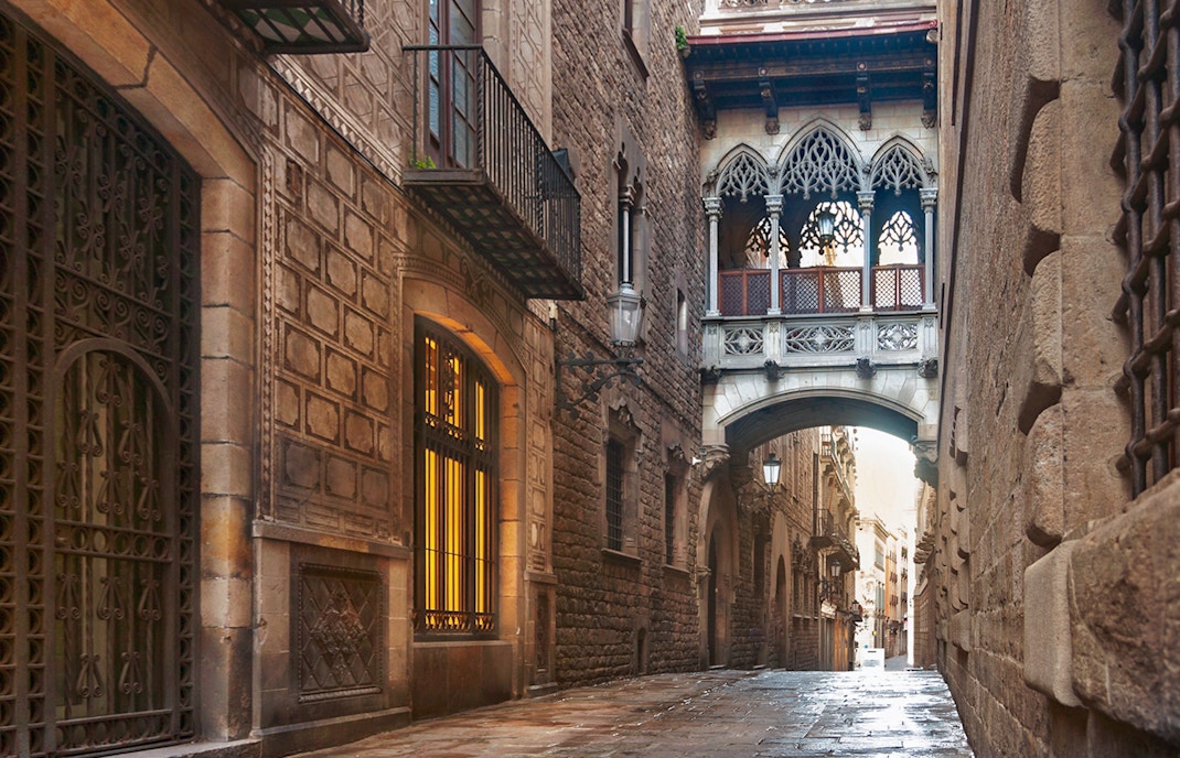 Gothic Quarter street with bridge in Barcelona, part of guided tour with music, history, and cava.