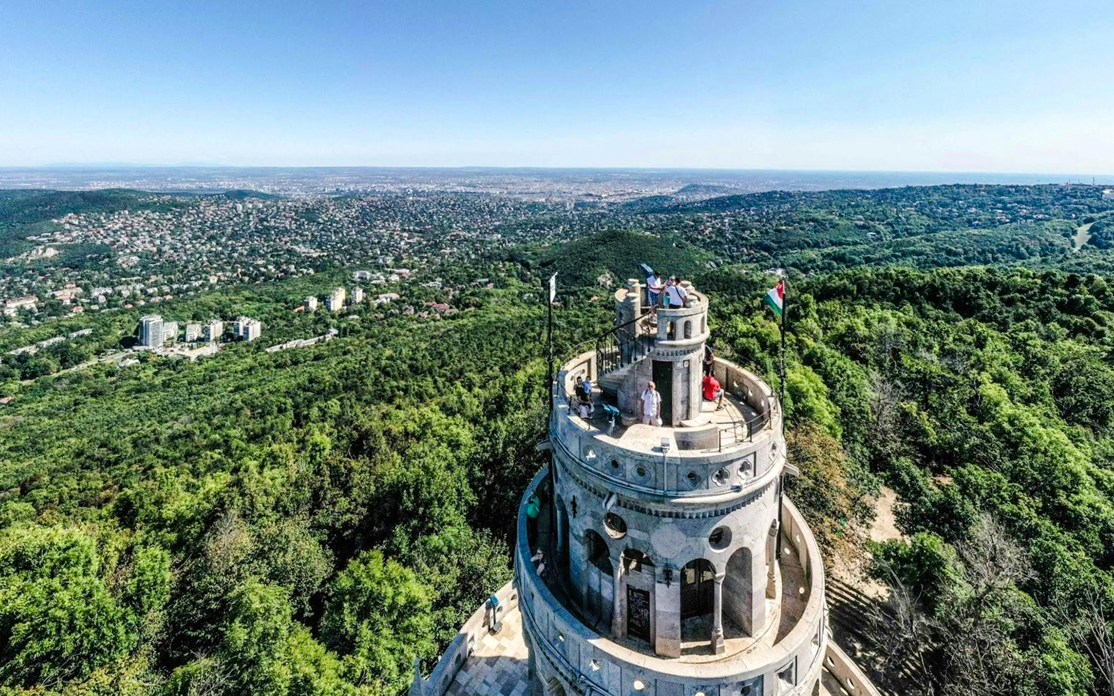 Aerial view of Janos Hill Lookout Tower surrounded by lush greenery in Budapest, Hungary.
