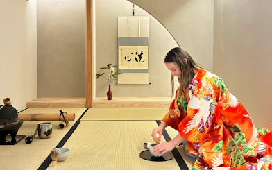 Tourist whisking matcha during a traditional tea ceremony in Kyoto, Japan.