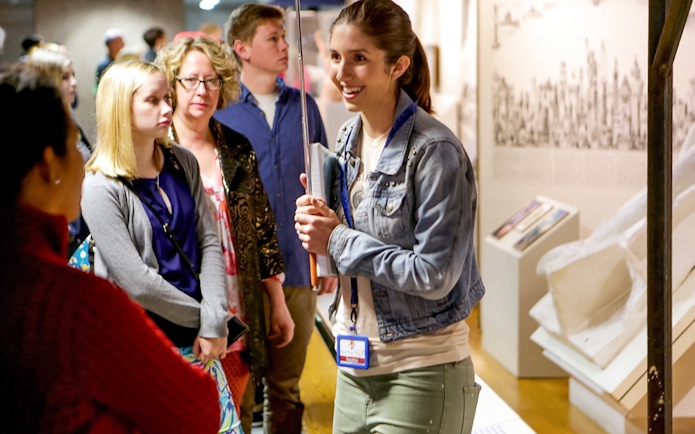 Guide engaging with tour group at Statue of Liberty exhibit.