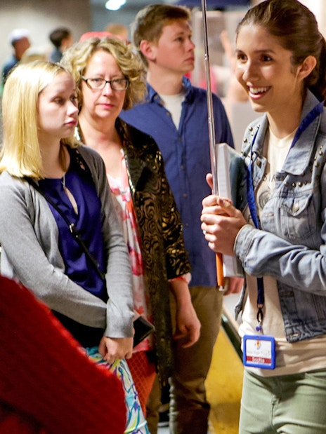 Guide engaging with tour group at Statue of Liberty exhibit.