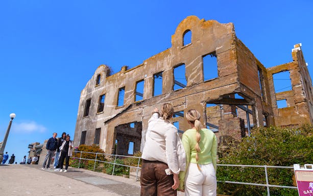Guests observing the ruins of the Warden's Cabin on Alcatraz Island.