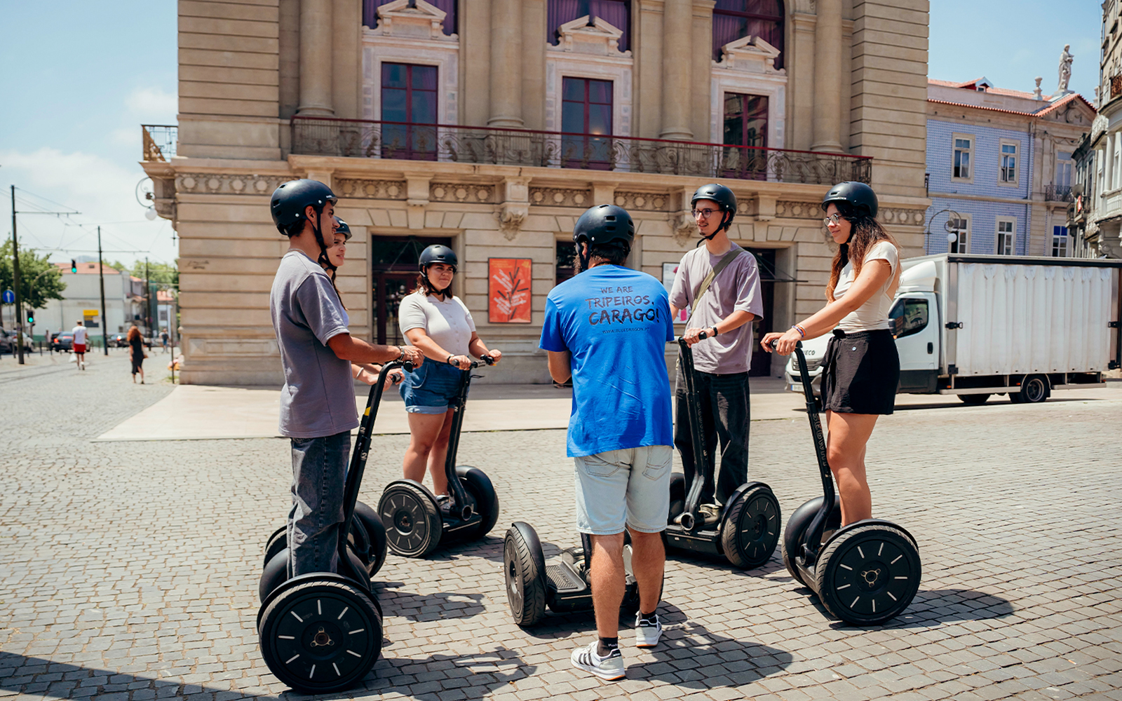 Tourists on Segways with guide in Porto city square.