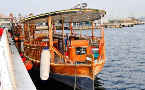 Traditional wooden abra docked for private Emirati seafood tour in Dubai.