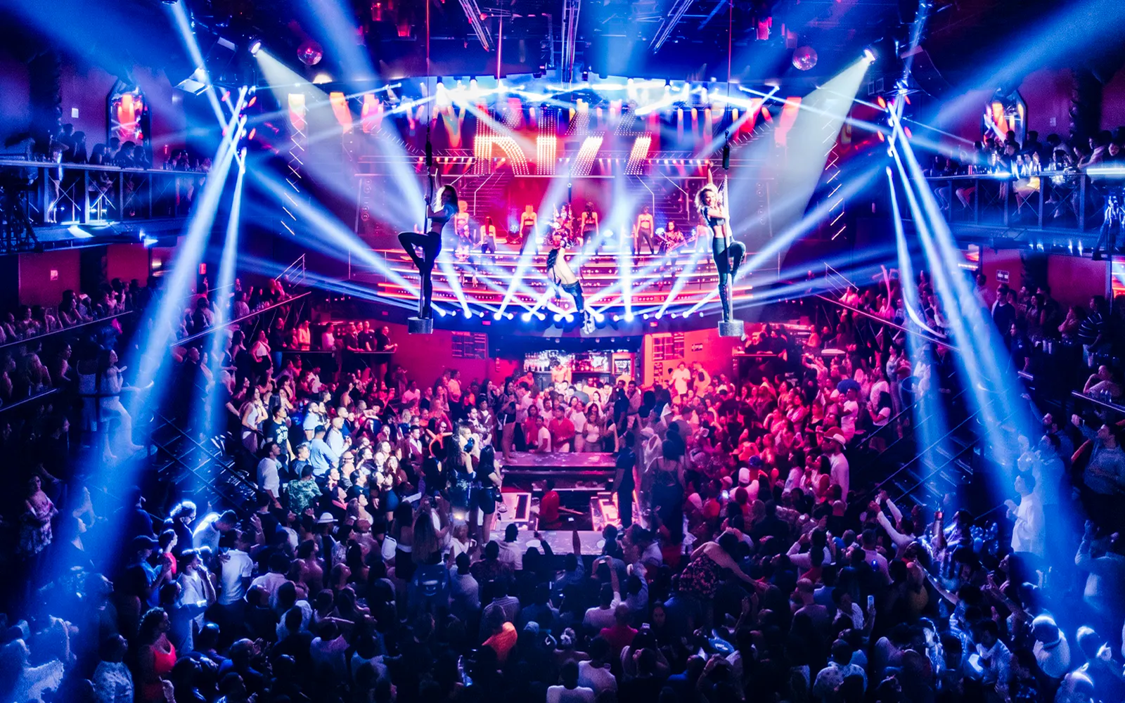 Crowded dance floor with aerial performers at Coco Bongo Club, Punta Cana.