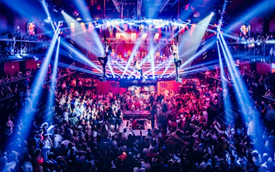Crowded dance floor with aerial performers at Coco Bongo Club, Punta Cana.