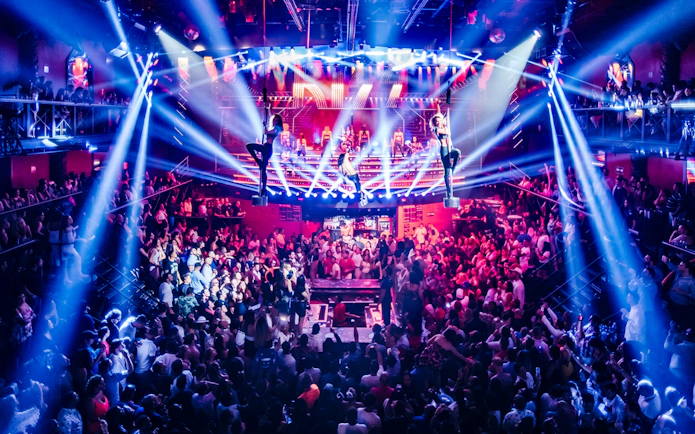 Crowded dance floor with aerial performers at Coco Bongo Club, Punta Cana.