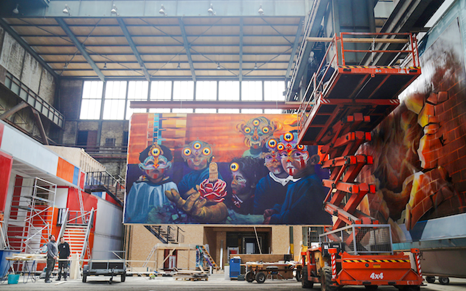 Mural titled "Sinister Hand" by Gleo in an industrial setting with scaffolding.
