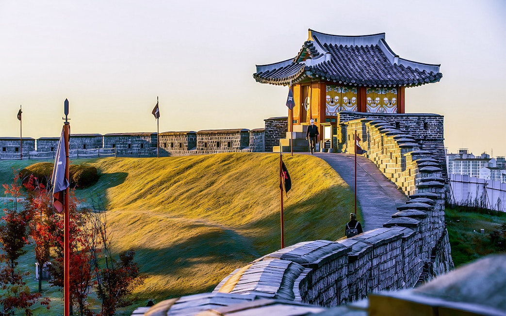 Suwon Hwaseong Fortress wall and traditional pavilion during Korean Folk Village tour.