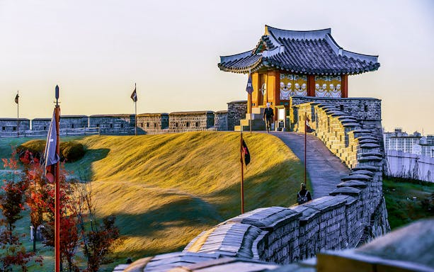 Suwon Hwaseong Fortress wall and traditional pavilion during Korean Folk Village tour.