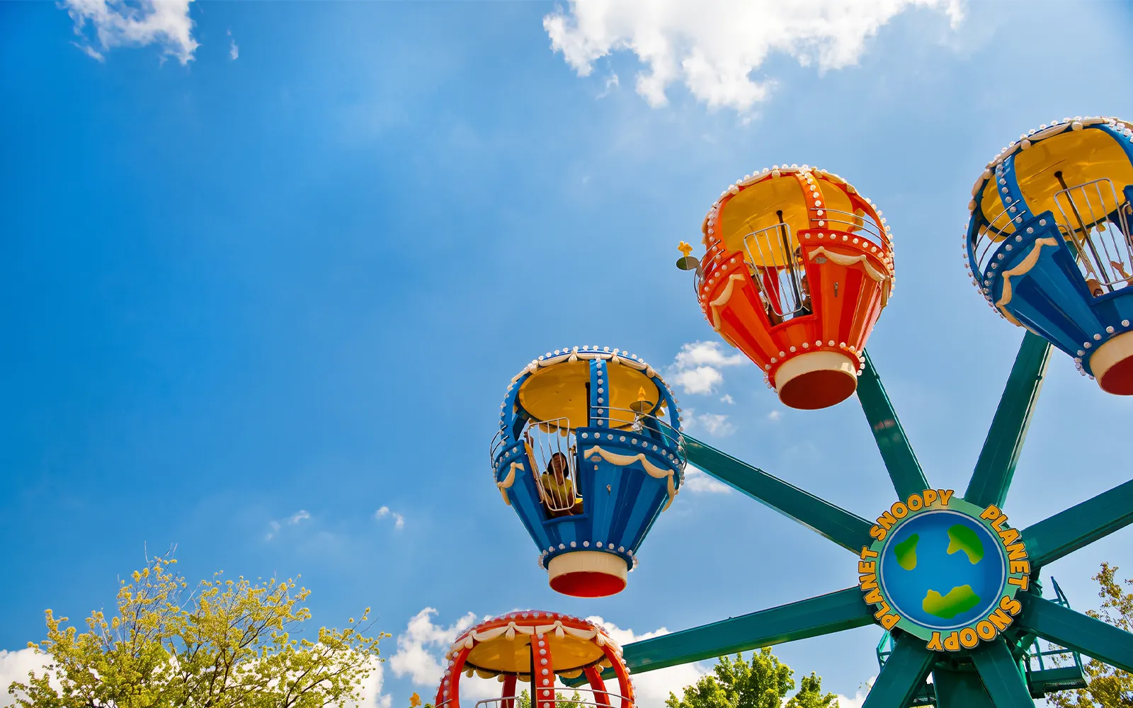 Snoopy's Revolution ride at Canada's Wonderland with colorful gondolas against blue sky.