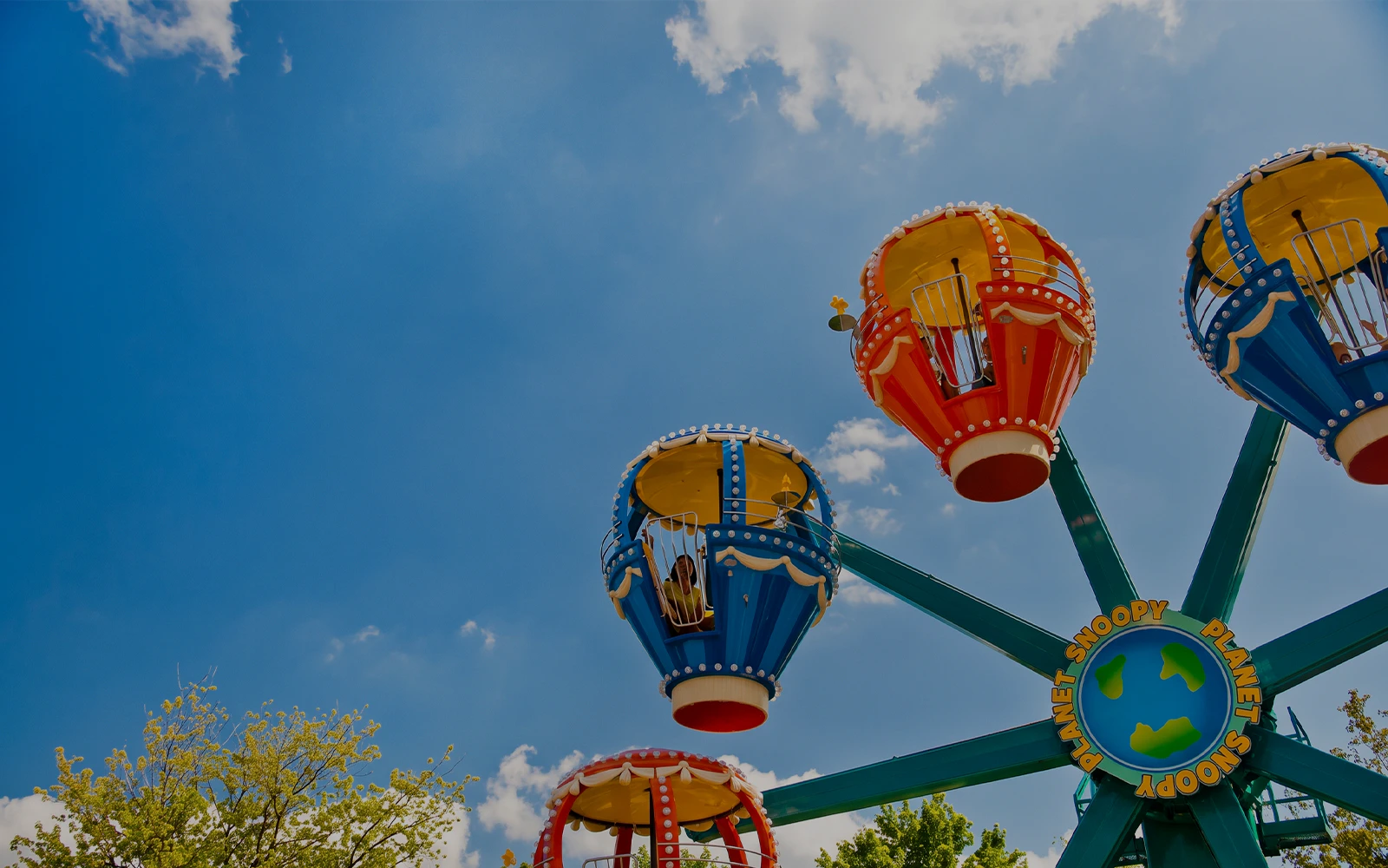 Snoopy's Revolution ride at Canada's Wonderland with colorful gondolas against blue sky.