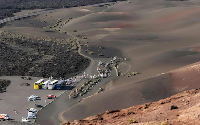 Aerial view of tourist buses and camel rides at Timanfaya National Park, Lanzarote.