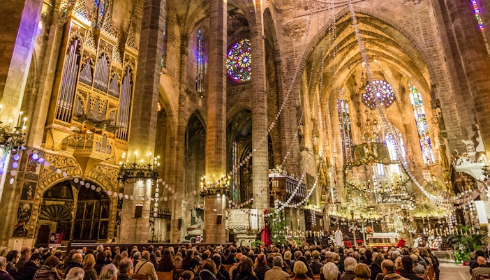 Palma Cathedral interior with congregation attending mass, Mallorca, Spain.