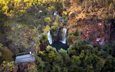 Litchfield National Park waterfall view from lookout platform, surrounded by lush greenery.