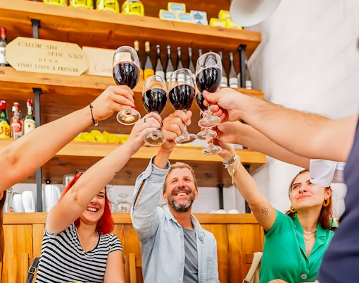 Tourists toasting with wine during Lisbon Food Walk in Baixa.