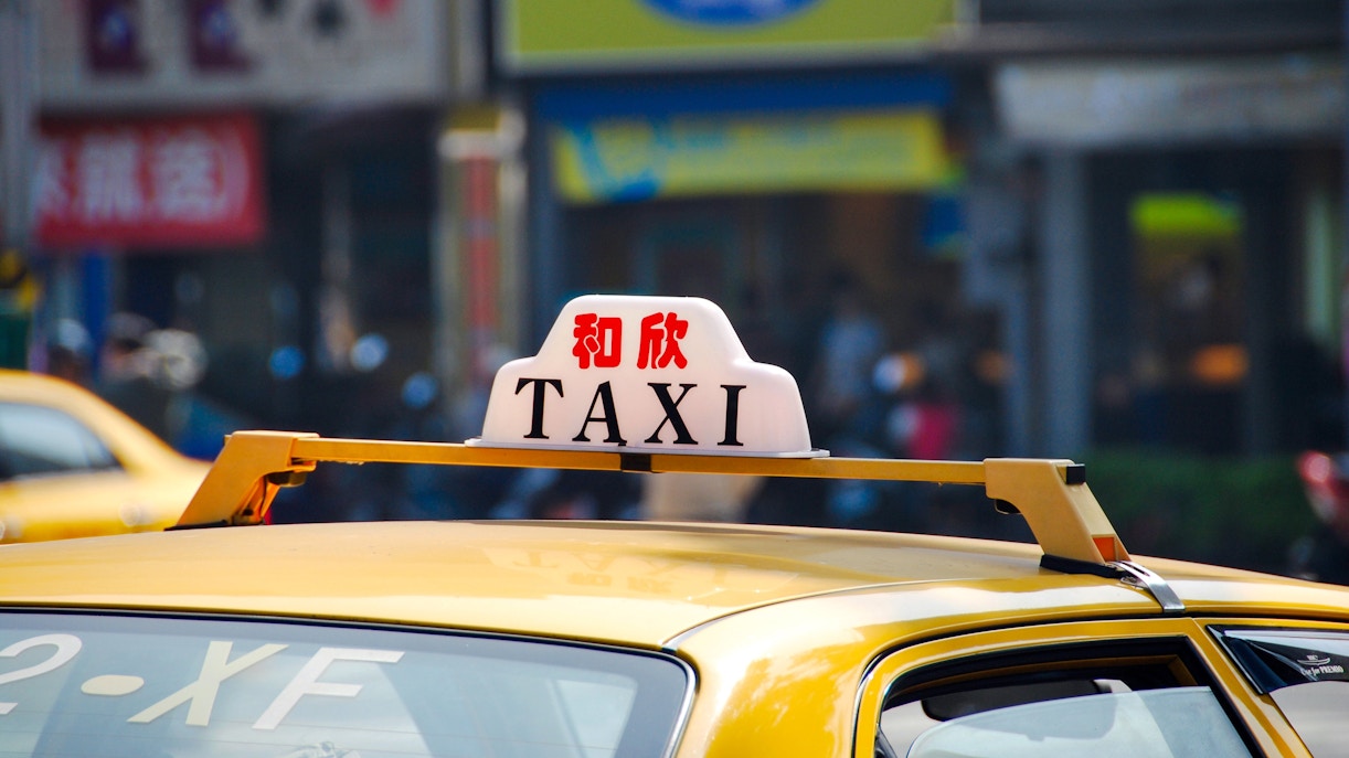 Yellow taxi with rooftop sign in Taiwan street.