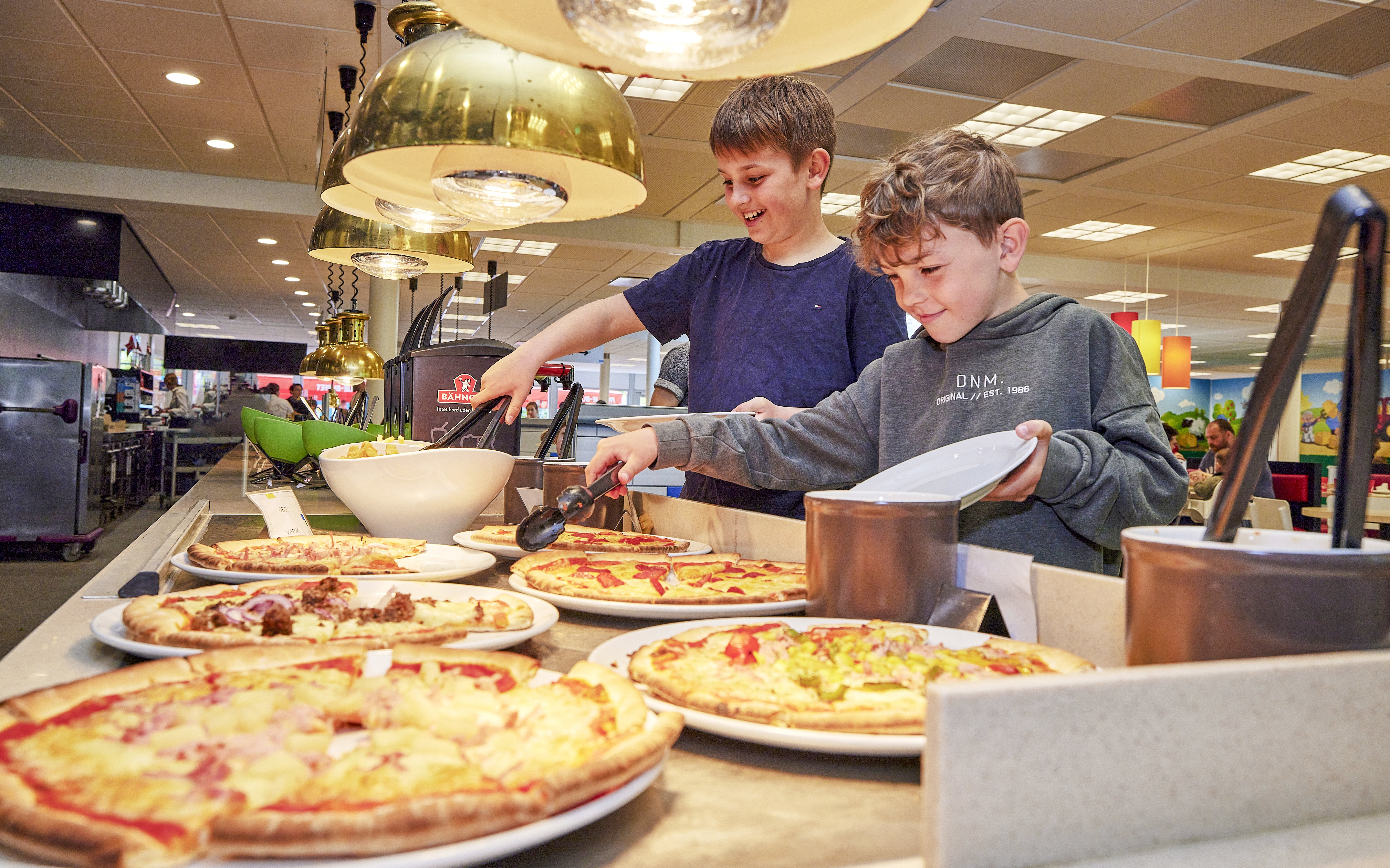 Children selecting pizza at a buffet in a cafe at LEGOLAND Billund.