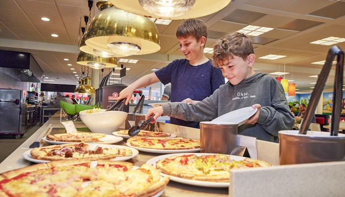Children selecting pizza at a buffet in a cafe at LEGOLAND Billund.