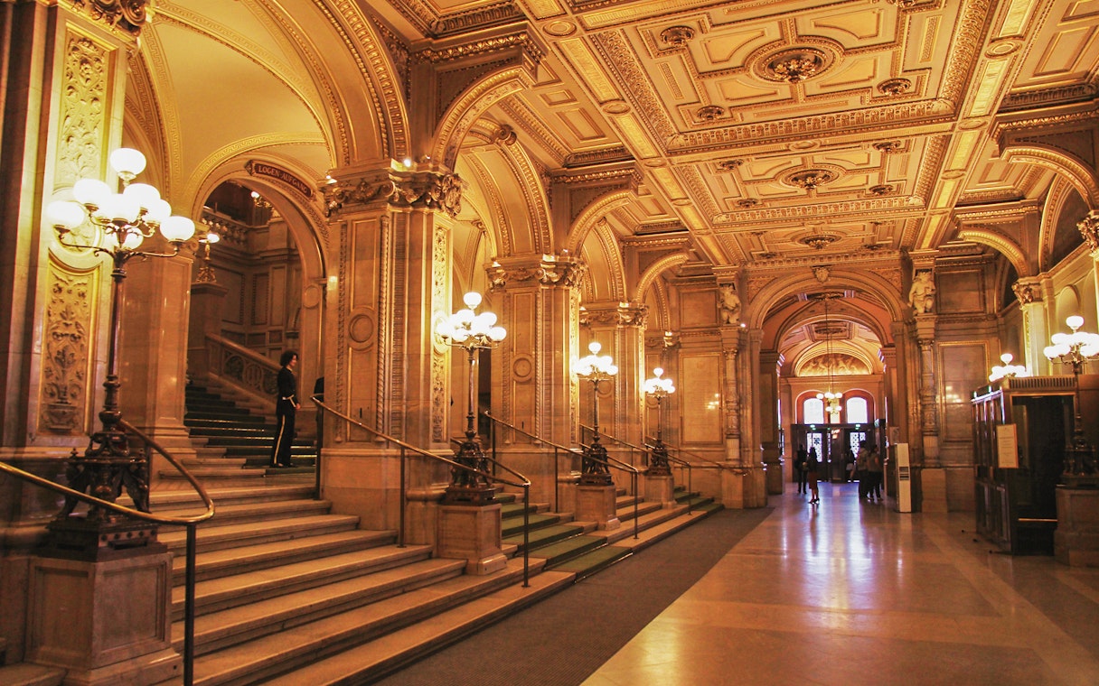 Vienna State Opera interior with ornate arches and grand staircase.