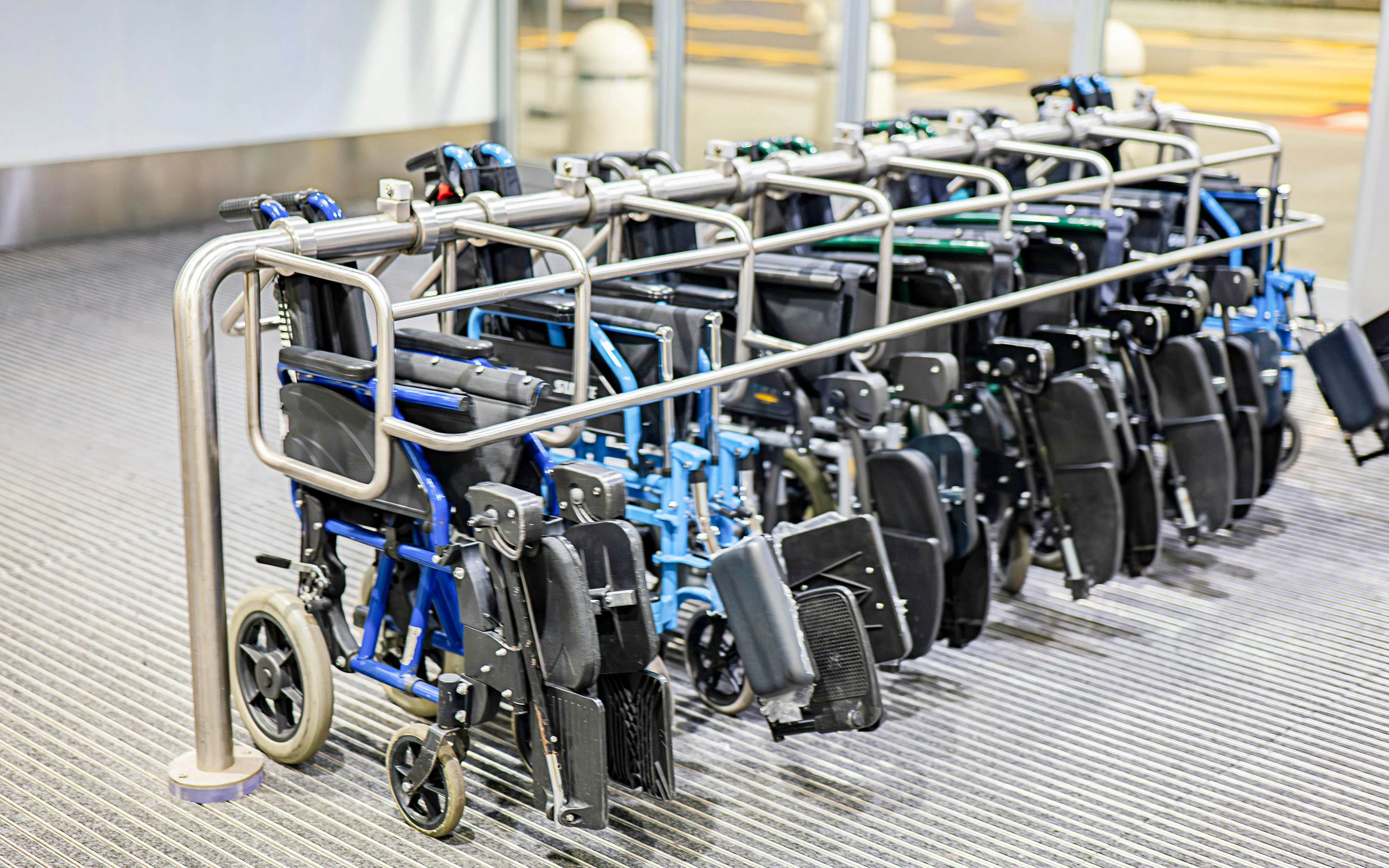 Wheelchairs lined up at an accessible facility entrance.